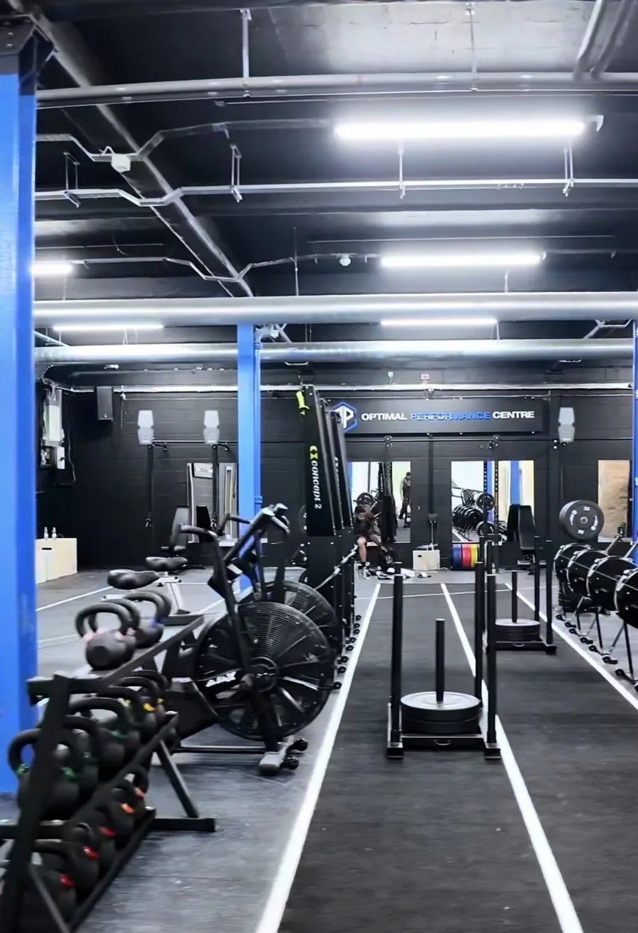 Kettlebells, sleds and free weights beneath the Optimal Performance Centre sign